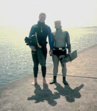 Divers walking out along top of the breakwater